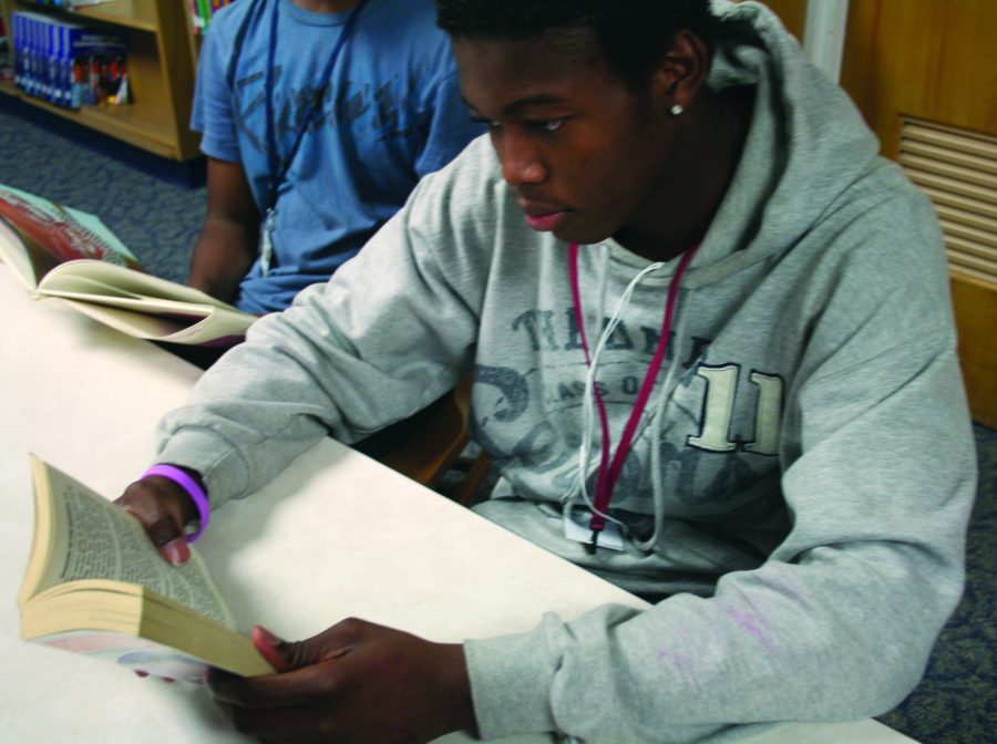 Juinor Marquis Norman reads a book during his english class. Norman likes to read during SSR.