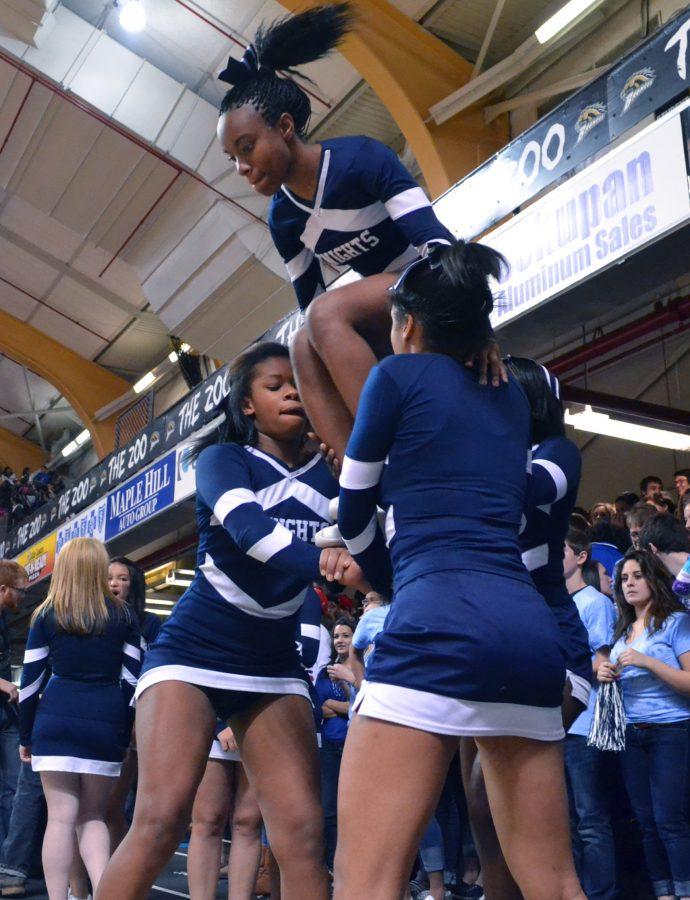 Senior Latroia Atkins is lifted to the top of the pyramid by fellow cheerleaders at the Kalamazoo Central game. The competitive cheer team has had a strong season. Photo by Racheal Koole.