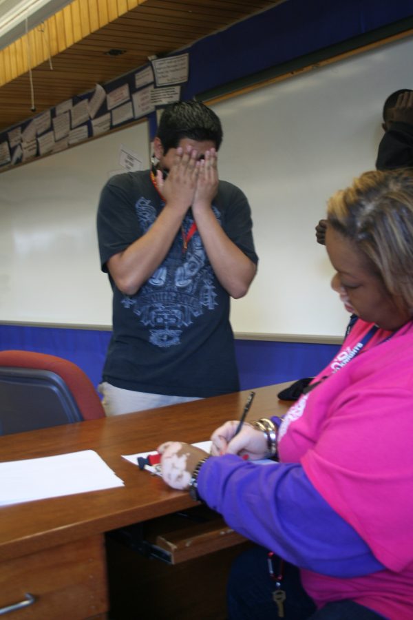 Fernando Juarico-Cervantes hides his face as DaNetta Blake signs him in to Hall Sweep. She tells him to take a seat in the fourth row, fourth seat. Cervantes sits among 16 other students at 1:20 pm.
Photo by Allie Creamer
