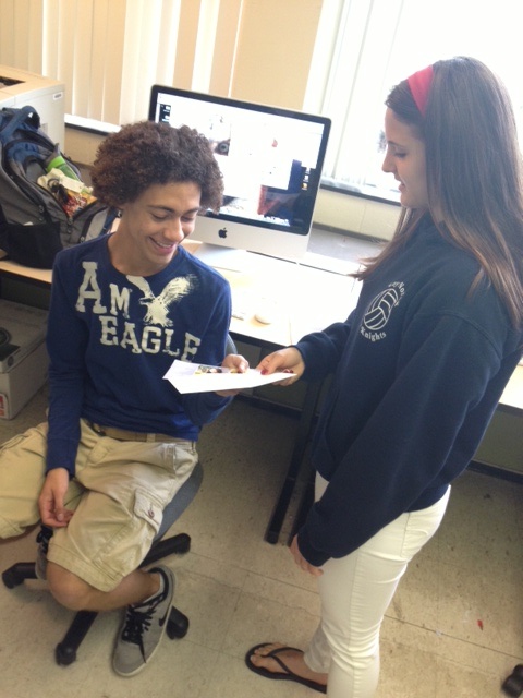 Photo by Mia Leibold 

Senior Erin Romph and Josh Johnson exchange graduation invitations in class. They are both having celebrations at their homes in June. 