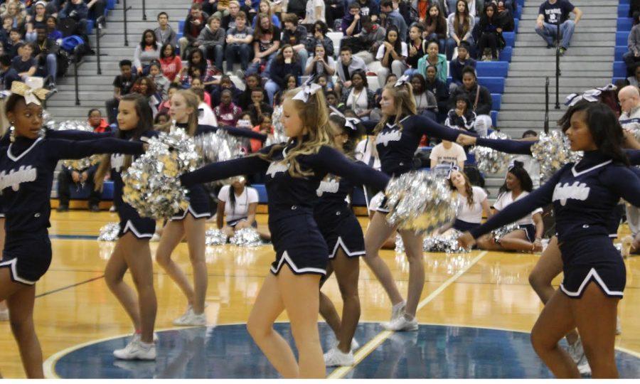 The varsity cheerleaders perform the pom pass during their pep rally routine. The pom pass took the cheerleaders hours to perfect. Photo Credit / Jordan Brown