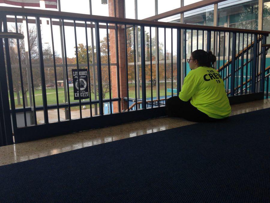 Junior and Link Crew Leader Veronica Verity sits stoically at the top of the tower during parent teacher conferences. She helps parents navigate Loy Norrix, but the crowd is underwhelming. Photo Credit / Sophia DeRango