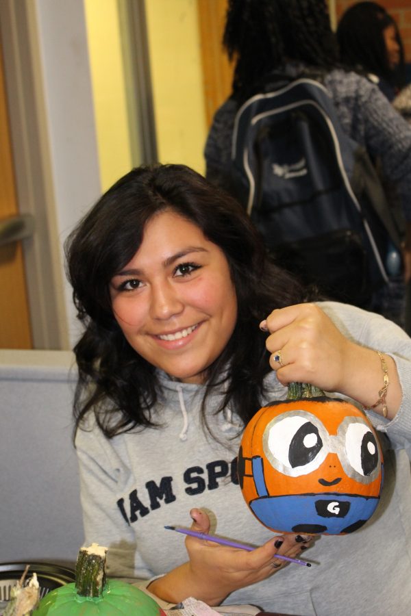 Senior Leslie Julian is painting a cheerful pumpkin in order to brighten up someones day. Photo Credit: Jonathan Lo