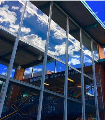 At the school of Loy Norrix, clouds roll over the sky. Looking into the glass of the school you can see a picture.  Photo Credit / Jakia Edmonson