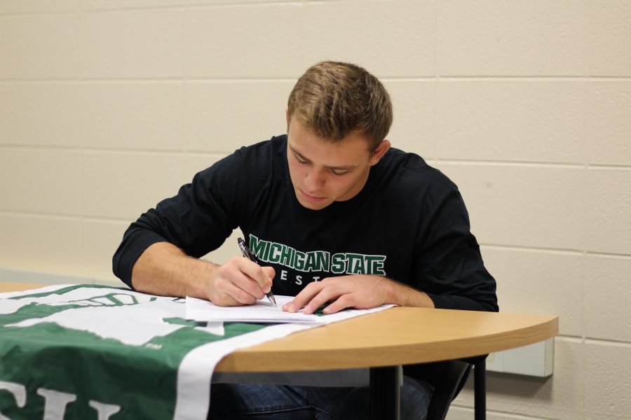 May signing the papers for a four year commitment to Michigan State.    May was the Michigan state runner-up last year in his weight class, last season. Photo Credit / Chris Hybels