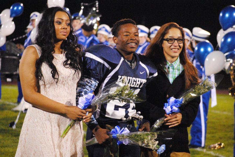 Seniors JeNessa Bogan, Aaron Holmes and Sabi Nieves walk down the decorated football field as part of the 2015 Homecoming Court. JeNessa Bogan and Sabi Nieves became the first same gendered King and Queen in Loy Norrix homecoming history.
Photo Credit / Cori VanOstran