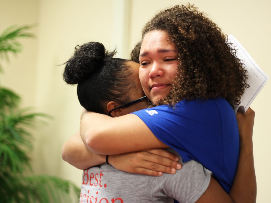 Haven Johnston embraces her good friend Maia Greer with happy tears in her eyes. They have both committed to different colleges and are very excited for each other. Photo Credit / Caitlin Commissaris