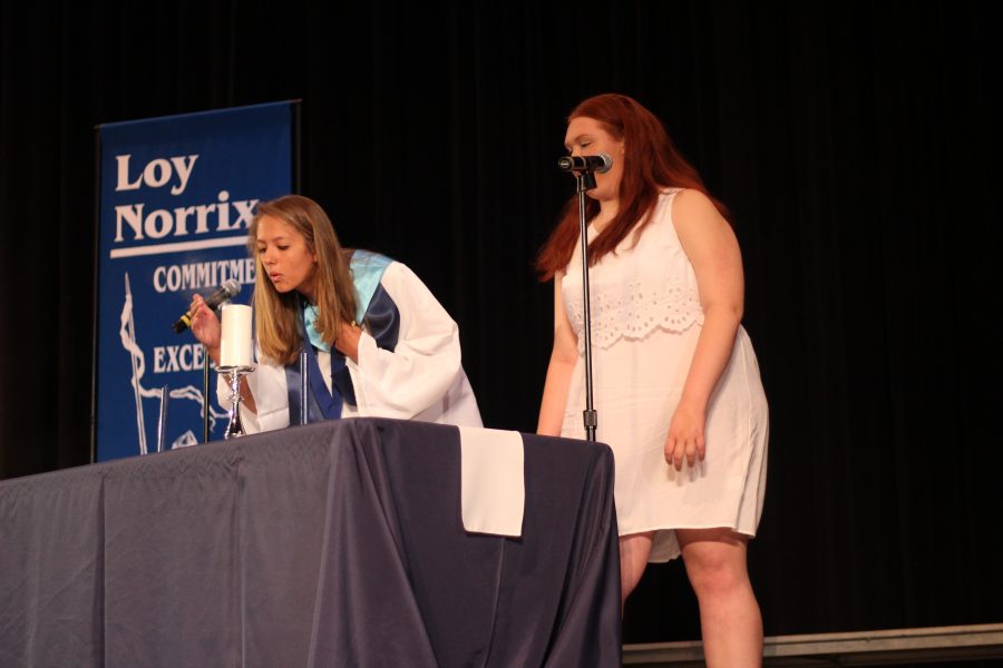 Senior class president Maddie Olech blows out the senior candle, passing it to the juniors. Photo Credit / Abby Farrer