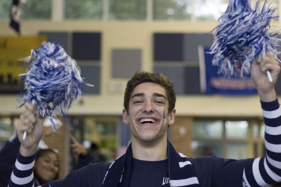 FRIDAY: Senior Vaughn Taylor shows his school spirit with blue and white pom poms. “I’m pumped for my last homecoming pep rally,” said Taylor. Photo Credit / Hannah Pittman