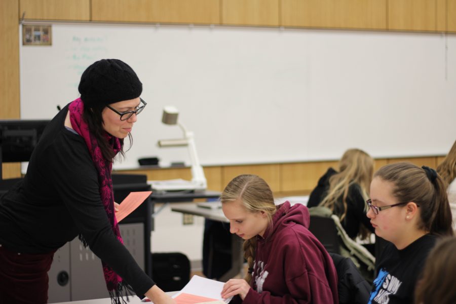 Becky Cooper helps students in her ATYP AP Literature & Language class at Western Michigan University. Pictured from left to right Becky Cooper, Emma Michael, and Lily Dorstewitz. Photo Credit / Frankie Stevens