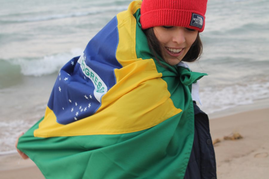 Isabela Seixas, a 18 year old exchange student from Brazil is proudly using her flag to warm her up in her host town Saint Joseph. Seixas has enjoyed her year in U.S. but her love and value of her home country has grown a lot. Photo Credit / Sarita Nieminem