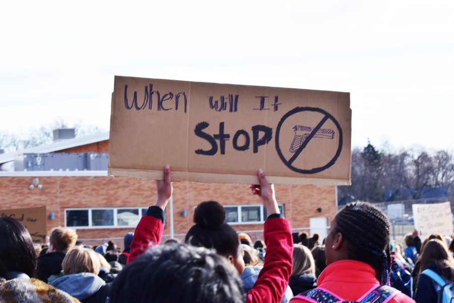 Loy Norrix student holds poster to protest gun violence. Photo Credit / Glenna Aldag