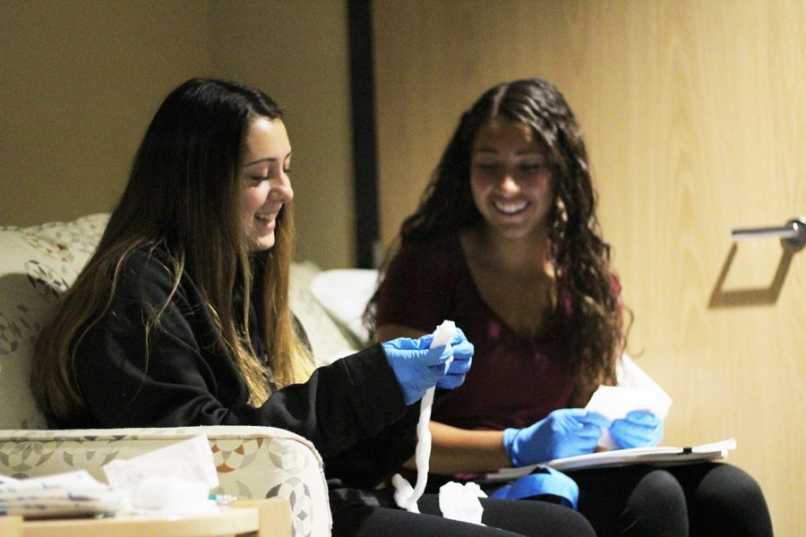 Portage Northern senior Paige Konigsberg and Kalamazoo Central senior Izzy Hawkes practice wrapping with dressing and pads during lab for the Emergency Medical Technician EFE. Wrapping and bandaging is a very important skill for EMTs to know.