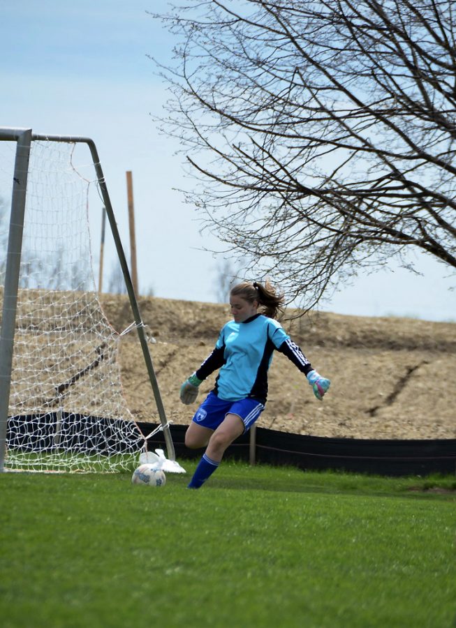 Goalie, Hannah Locke, kicks the soccer ball out from the net. Hannah played a big role during a big away-match.