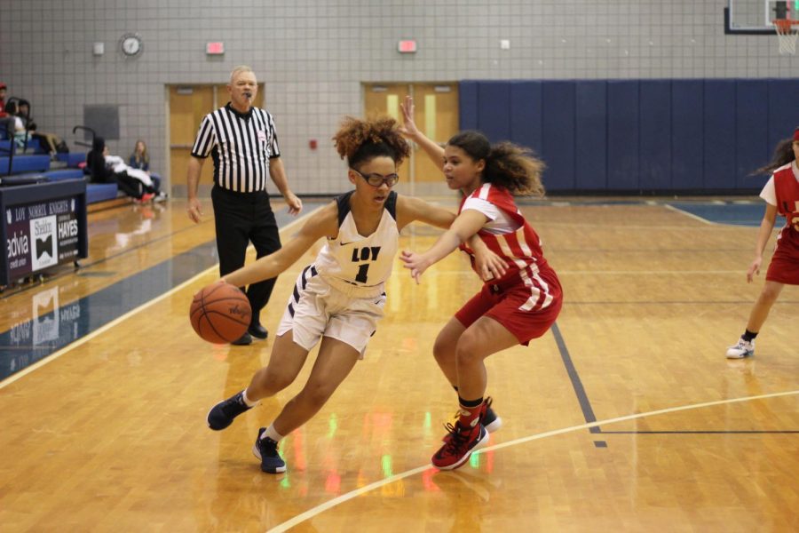 Junior varsity and sophomore Vicky McGowan dribbles around her opponent in an attempt to score a basket. McGowan scored a total of eight points in the game against Grand Rapids Union high school.