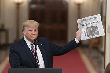 President Donald Trump holds up a copy of The Washington Post headlined with Trumps acquittal. President Trump was acquitted on February 5, 2020. 