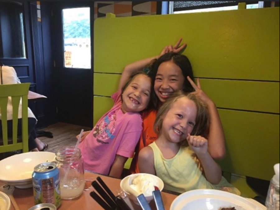 Young Alice Wadsworth-Curcuru (left), Wen Wadsworth-Curcuru (middle), and Téa Wadsworth-Curcuru (right) celebrating a birthday at a restaurant.  The siblings are now ages 14, 18, and 12. 
