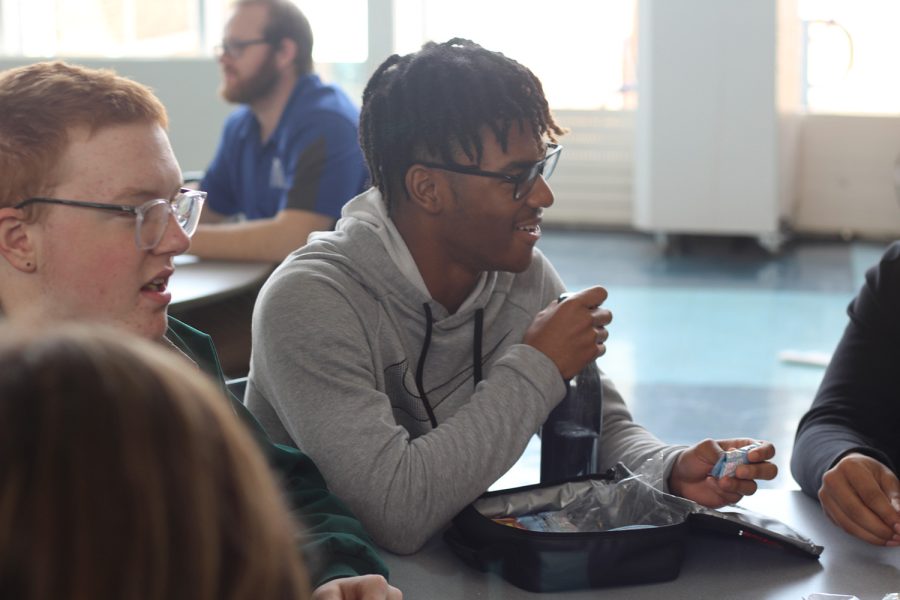 Junior Micah Johnson talks with his friends at the lunch table. Lunch is one of the many places where students interact and connect with one another. 

