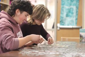 Senior Kate Suarez and sophomore Alaina Suarez work on the puzzle together. The puzzle can be worked on in the morning, during all lunch periods, or any school hours when the library is open.
