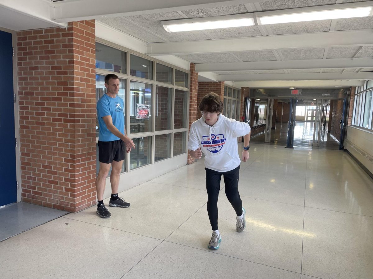 Sophomore Jackson Lam practices his sprint form at indoor track practice. Track and Field coach Bradley Schmidt gives Lam advice to perfect his form.