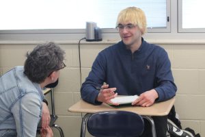 Spanish teacher, Kristin Antoniotti, helps students further understand the conflict in the Spanish led story, acted out earlier in the classroom. Antoniotti encourages Mitchell Quick to participate in the class activity.