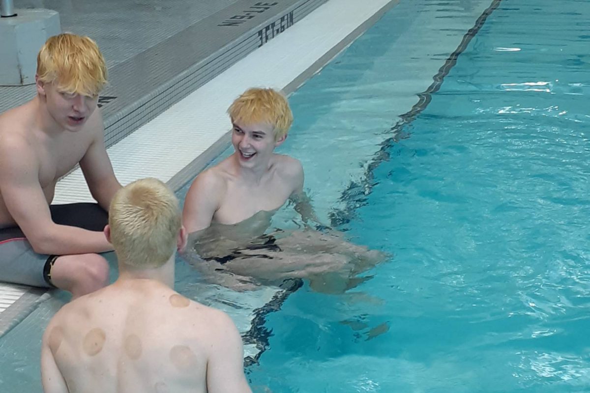 Swimmers Isaac Patrick, Westlee Weston and Zander Ligman relax in the Lakeview High School pool in Battle Creek before they swim again. The meet is coming to a close and soon these swimmers will have to go home and do their homework.
