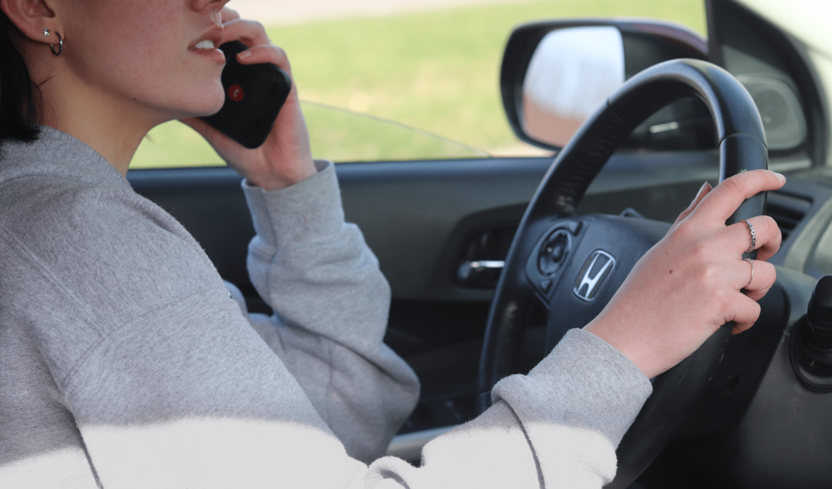 (Photo Illustration) A student drives her car while talking to someone on the phone. This violates Kelsey’s Law which prohibits drivers from using their cell phone while driving. 