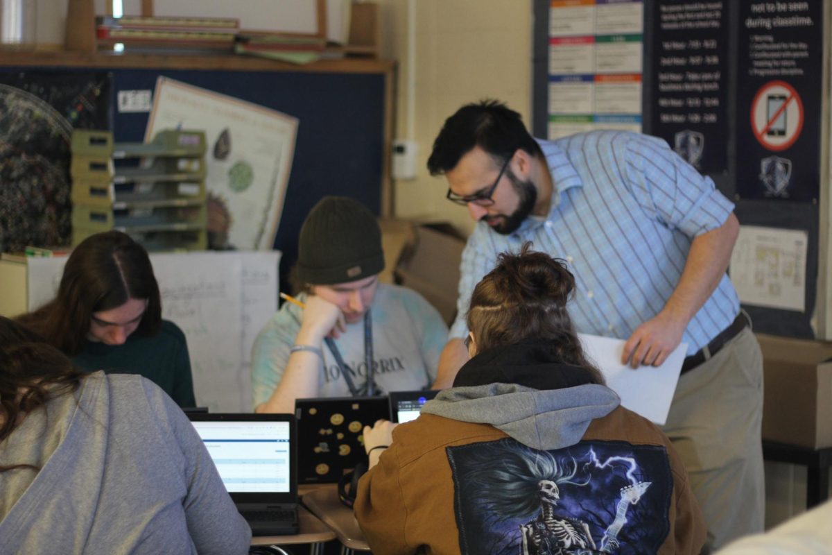 Latin teacher Dyami Hernandex helps his second hour class choose classes for next year. Before selecting what classes they want, students have to check what credits they have first.