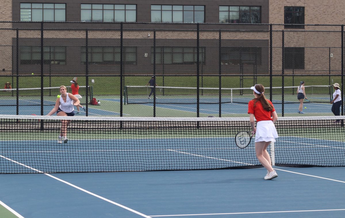 Varsity+tennis+player+Shiloh+Schrader+strikes+the+ball+over+the+net+in+a+1v1+against+Portage+Northern.+The+match+ended+in+a+6-2+win.