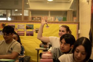 Junior Amaris Grubaugh raises a hand to ask a question about Economics teacher Ryan Allen's presentation about the Federal Reserve.