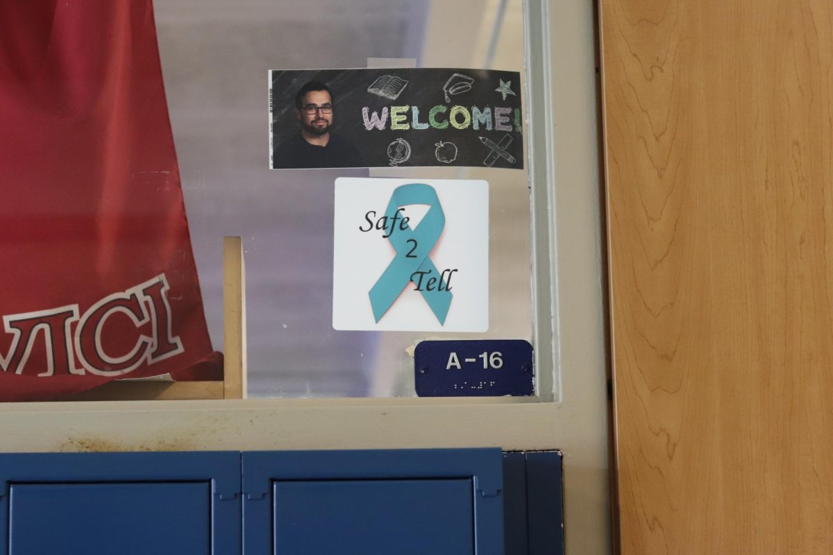 As students walk the halls on their way to their classes, theyre reminded that there are staff who are safe to tell. If they are experiencing abuse, harassment, mental health declines or other struggles, they can reach out to the teachers who have these teal ribbons displayed in their classrooms.