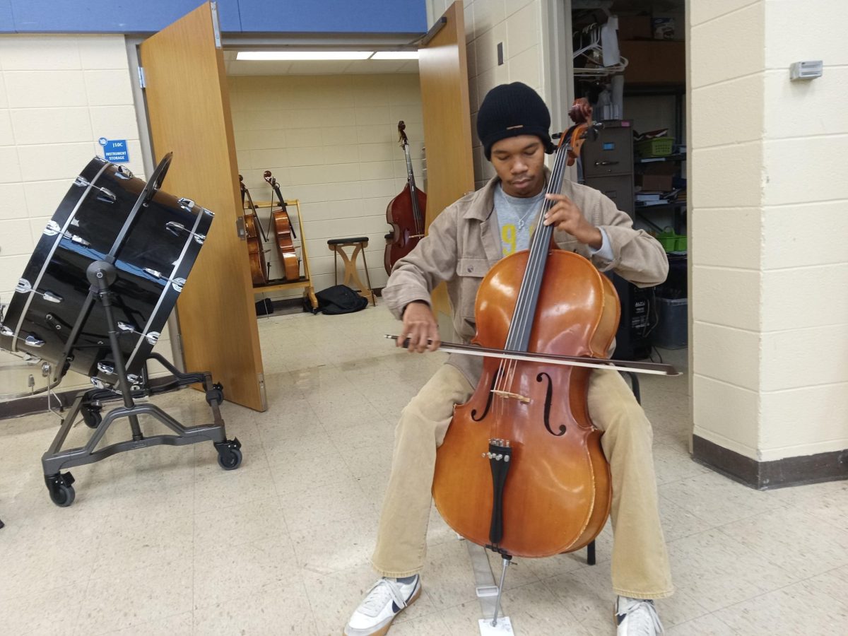 Junior Cory Roberts plays the cello during his lunch period. Roberts has played cello since fifth grade, but no longer participates in the school orchestra.