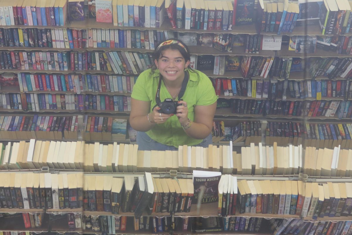 Student journalist Isabella Figueroa smiles as she takes a photo of herself in the mirror. Last year, she reported on Michigan News Agency owner Dean Hauck’s way of understanding her community and her people.