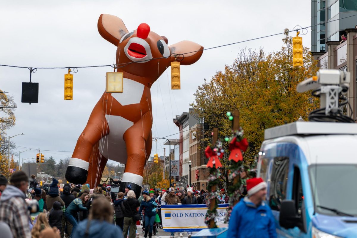 A balloon of Rudolph the Red-Nosed Reindeer is pulled down the parade route. The balloon had to be lowered and raised to avoid traffic lights during the parade. 
