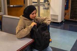 Sophomore Farah Al Hasan sifts through her backpack at lunch. She always wears her hijab at school, as it is an important part of her Islamic faith. 