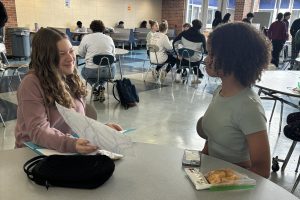 Freshman Ella Harrison enjoys socializing while she eats. Harrison gives constructive criticism to her friend's recent art project.