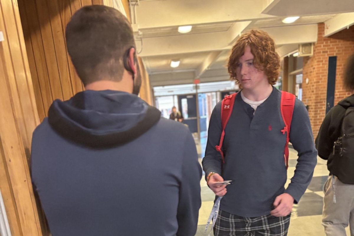 Andrew Muysenberg scans Sophmore Aiden Corbett's ID after lunch to issue him a pass. This process takes place either at the schools tower or cafeteria entrance to ensure students can promptly return to class, part of the Hero Pass system that promotes accountability." 

