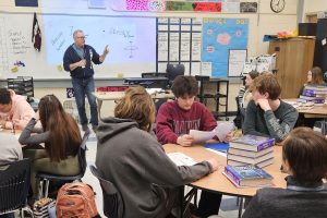 Freshman Gabriel Solitro looks over his packet, not paying attention to his teacher. Having to catch up due to being late can cause students to fall behind in work. 