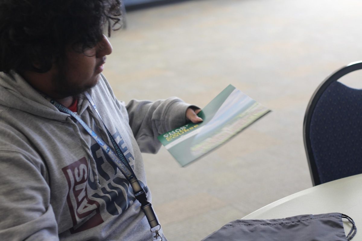 Senior Jose Garcia pulls out an SMC brochure from his string bag. Like Garcia, students were given string bags containing contact sheets and brochures as they entered campus.