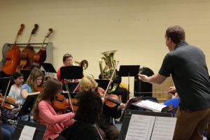 Conductor Benjamin Gudbrandson sets the tempo for the orchestra. Gudbrandson has been teaching for over 11 years. 