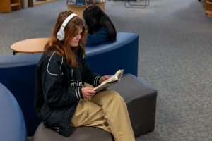 Junior Mary Ewing reads a book in the library for Mary Johnson's English 11 class. Some teachers take their classes to the library for a change in scenery.  
