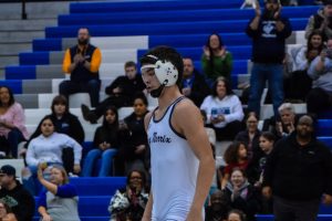 Junior Wyatt Buddemeier walks to the center of the mat after pinning his KC opponent. His match would later help contribute to the overall win against KC.