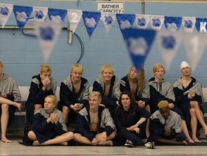 The men's swim team with their bleached hair. They cheer on the seniors while their swim team graduation ceremony takes place.