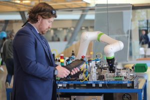 A technical assistant in the Mechatronics lab operates a piece of equipment using a tablet. This is one of the many pieces of high-tech equipment in the mechatronics lab. 