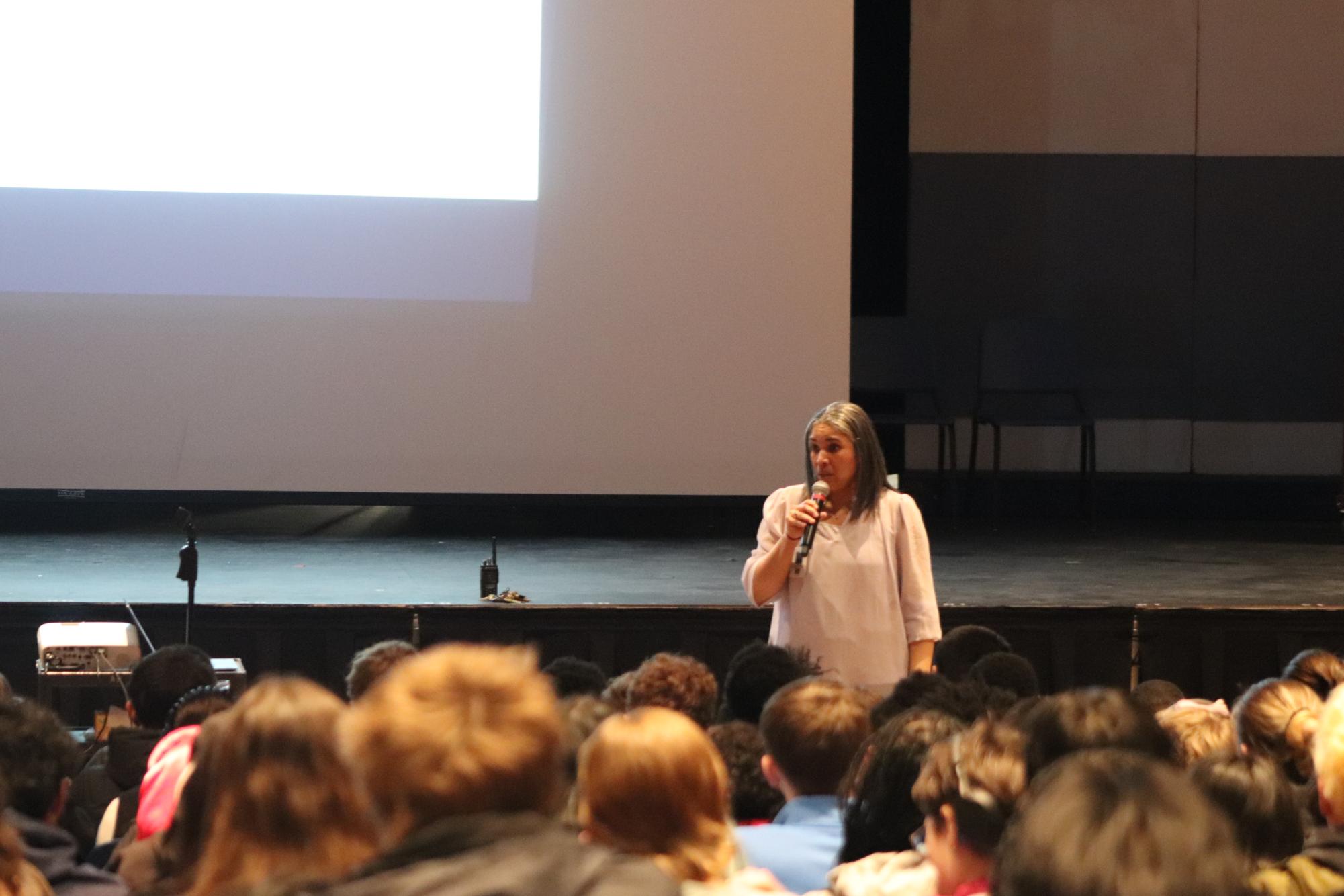 Dean of Students Stephanie Perry speaks to senior students about credits needed to graduate in senior meeting.